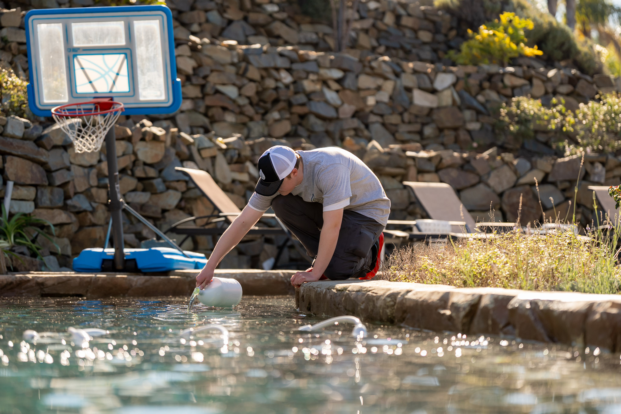 Nevergreen tech adding chemicals to balance pool water